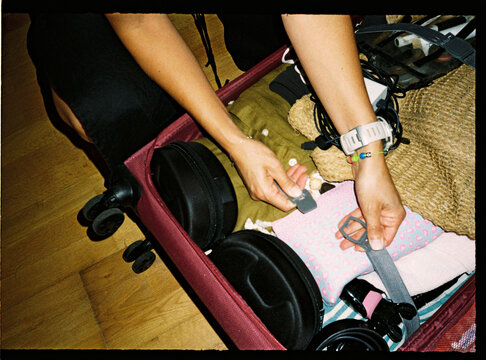 Hands organizing contents in suitcase for travel preparation