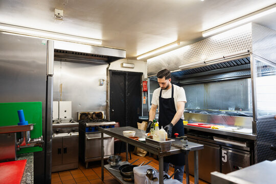 Wide shot of a professional chef working in a commercial kitchen