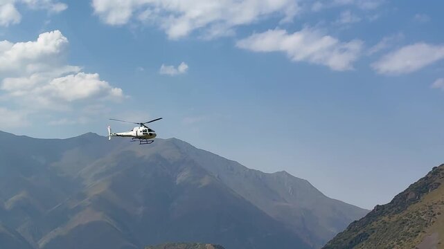 Rescue helicopter flying over the mountains in Ala Archa National park in Kyrgyzstan