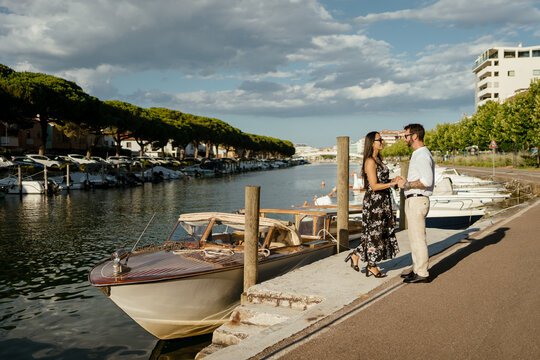 Couple Enjoying Leisure Time on Dock near a Speedboat