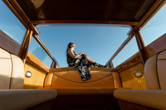 A woman on a luxury boat during a private tour at sunset