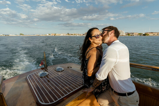 Romantic Couple embracing and kissing on a boat tour at sunset