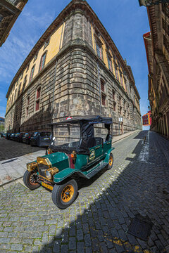 PORTO, PORTUGAL - APRIL 10, 2024: Funny Electric car called Tuk-Tuk Car which symbolizes a vintage car, used for tourists transport on the city streets.
