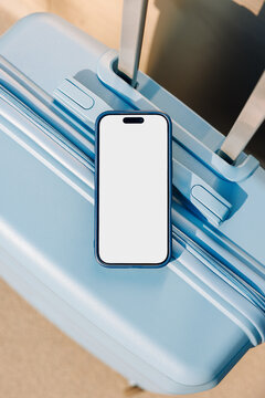 Travel smartphone mockup with white screen on blue suitcase