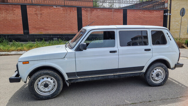 Side view of a white 5-door Lada Niva VAZ-2131 off-road vehicle in front of a red brick wall in Astrakhan; a Soviet classic with all-wheel drive, Astrakhan, Russia 13.05.2025