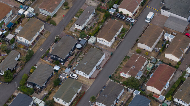 Aerial view of a residential park with numerous mobile homes, paved streets, and small private gardens in Rochester, England, United Kingdom.