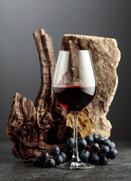 Red wine with stone, dried snags, and blue grapes.