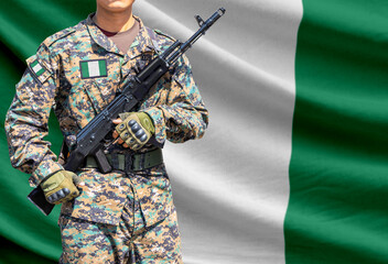 Fototapeta premium Nigeria flag with soldier holding assault rifle