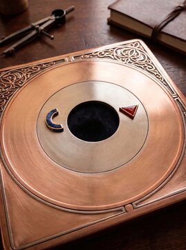 Oggetto metallico con simboli colorati su tavolo di legno  