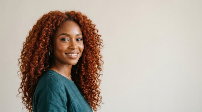 Portrait of young smiling woman with long curly auburn hair