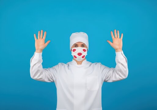 Medical professional in white uniform and mask with kiss print pattern raising hands