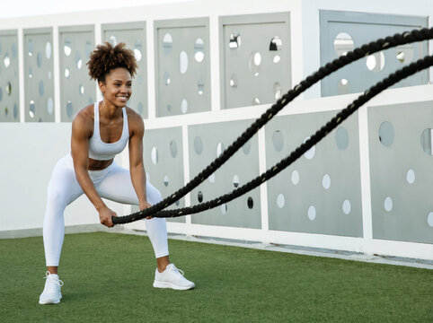 Young woman exercising with ropes.