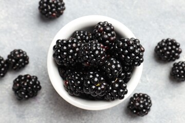 Ripe blackberries in bowl on light grey table, flat lay © New Africa