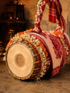 Decorated Dhak Drum with Floral Garlands and Oil Lamps