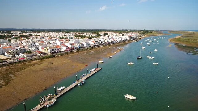 Beautiful aerial view of cabanas de tavira, a traditional fishing village in the algarve region of southern portugal, showing boats moored in the ria formosa natural park on a sunny day