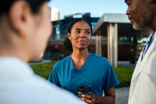 Healthcare workers talking during break outside hospital