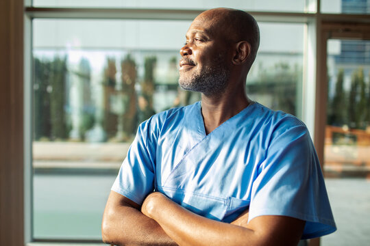 Confident healthcare professional looking out hospital window