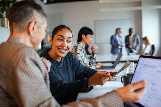 Diverse coworkers collaborating on documents in a modern office