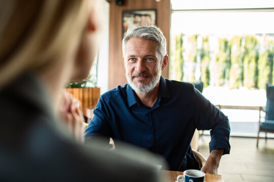 Mature man meeting with colleague in cafe