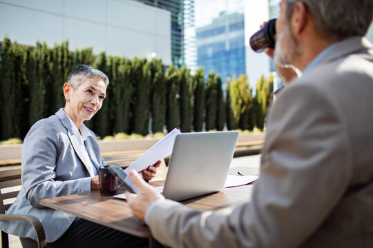Senior business colleagues meeting outdoors at cafe