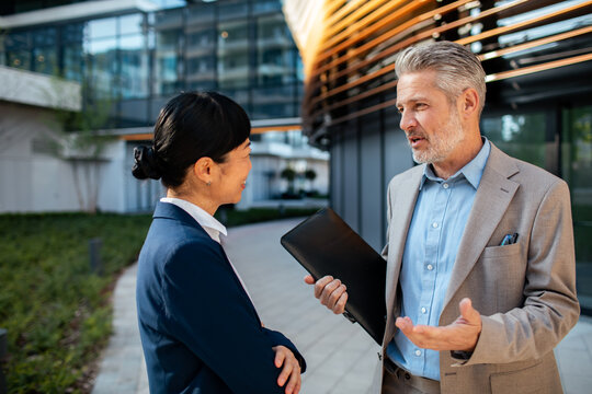 Business professionals discussing project outside office