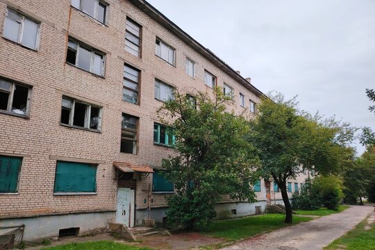 Abandoned and ruined soviet era brick apartment building with broken windows