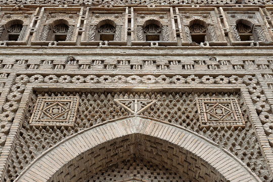 Ornamental brickwork detail of the Ismail Samani Mausoleum in Bukhara, Uzbekistan. Intricate geometric patterns and arched niches showcase medieval Central Asian craftsmanship, ideal for travel.