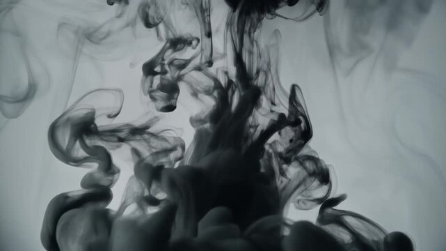 Minimal black ink waves gently oscillating in water creating abstract monochromatic smoke patterns and fluid motion on a gray background