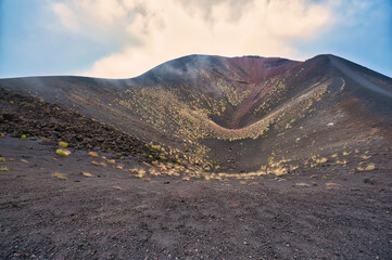 Interior view of a Silvestri crater on Mount Etna with sparse vegetation and hikers on the rim, Sicily, Italy © Filippo Labate