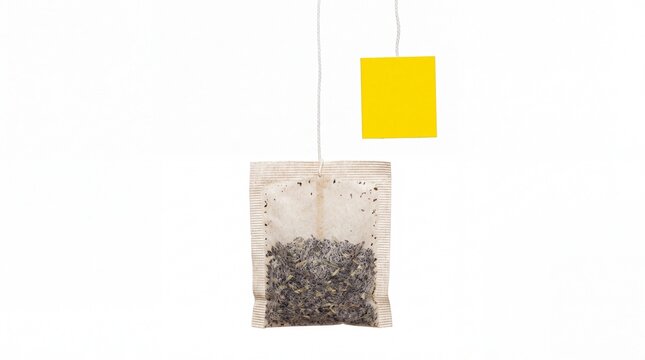 Single herbal tea bag with a bright yellow paper tag hanging vertically captured in high resolution isolated on white background