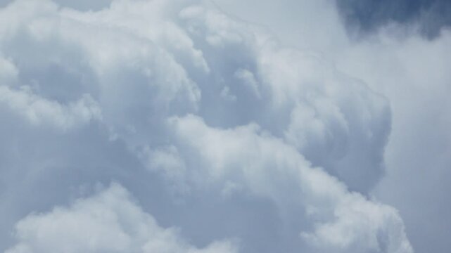 Zoom out from closeup of cumulus cloud to larger but incomplete view of approaching storm system on a hot summer afternoon in southwest Florida. Extreme long shot of sky only.