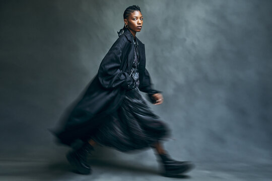 Fashion Model in Black Coat Walking with Motion Blur