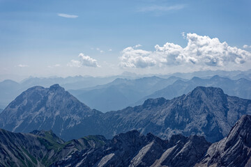Fototapeta premium Layered Alpine Mountain Ranges and Paraglider Viewed from Zugspitze Summit