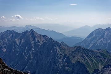 Obraz premium Layered Alpine Mountain Ranges and Paraglider Viewed from Zugspitze Summit