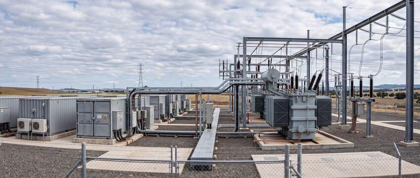 Electrical substation with power transformers and high voltage lines in rural landscape showing energy infrastructure