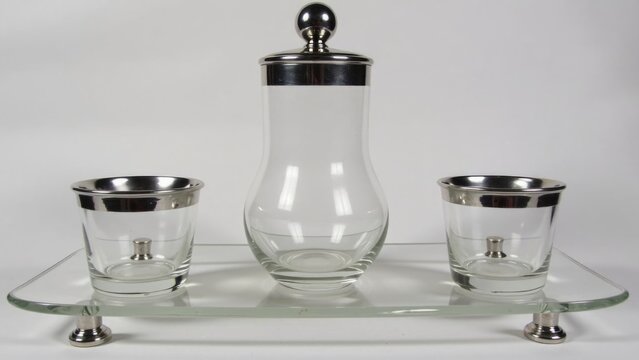 A set of three glasses and a decanter on a tray, perfect for serving wine or other beverages