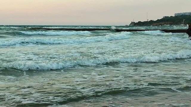 Big waves with white foam on sea on backdrop of sunset and dawn. Storm. Blue sea and sky. Stormy sea. Coast sand seashore. Seaside shore coastline. Natural background nature backdrop storm
