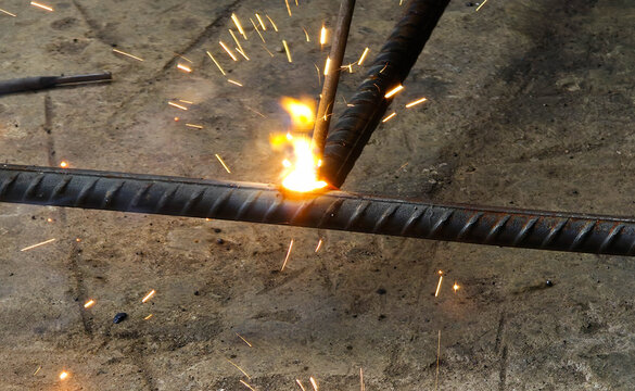 Metal welding sparks flying from steel rebar construction work