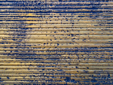 Abstract macro texture of weathered blue painted wood planks with horizontal grain lines.