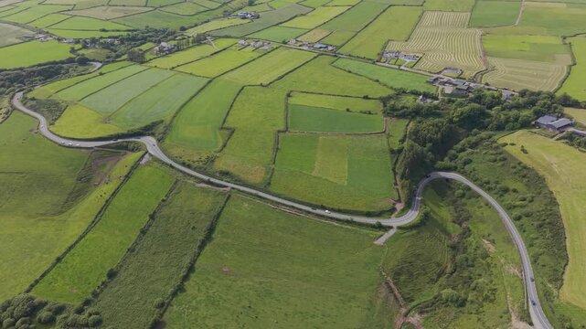 Cinematic aerial panning view of a car driving on the winding N86 road near Annalack Viewpoint on Dingle Peninsula County Kerry Ireland
