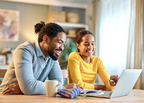Father and daughter doing homework with laptop at home. Father and teenage girl happy using laptop. Teen girl and dad sitting at home working with notebook