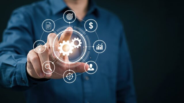 A businessman touching a digital screen interface displaying business management icons and gears. Perfect for corporate process optimization and technology concepts.