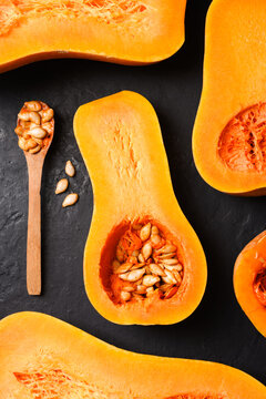 Butternut squash and wooden spoon arranged in graphic autumn composition. Seasonal food flat lay with pumpkin and harvest ingredient styling