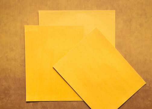 Photo of scattered blank yellow orange papers flat lay background