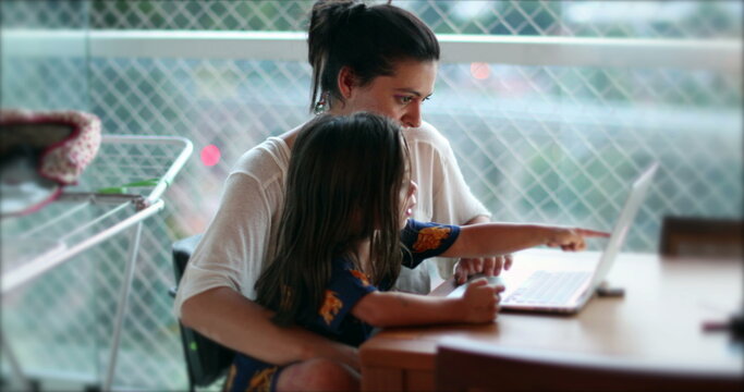 Candid authentic mother daughter child together in front of computer screen browsing the internet
