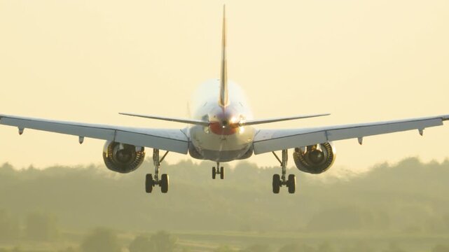Passenger airplane landing on the runway at sunset