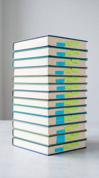 Stack of hardcover books with colorful sticky tabs, representing knowledge, study, and organization, ideal for educational or research concepts