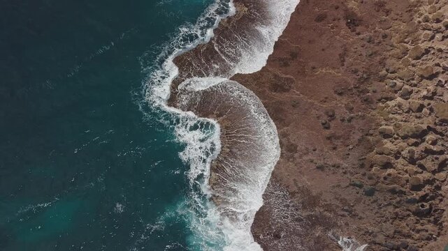 Aerial top down view of the Hawaiian shore with powerful waves breaking over the reef