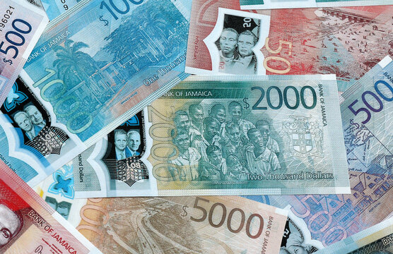 Jamaican dollar money banknotes pile on table. Jamaica bills of JMD currency close up