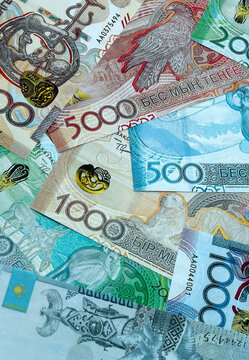 Kazakhstani tenge money banknotes pile on table. Kazakhstan bills of KZT currency close up